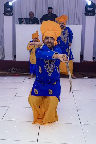 Bhangra dancer performing with a sword on the dance floor