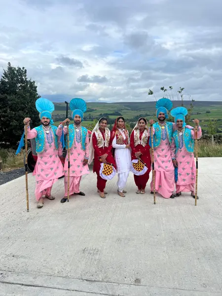 Bhangra dancers in matching outfits posing outdoors