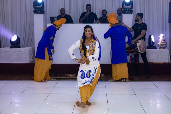 Bhangra dancers performing a routine around a female dancer