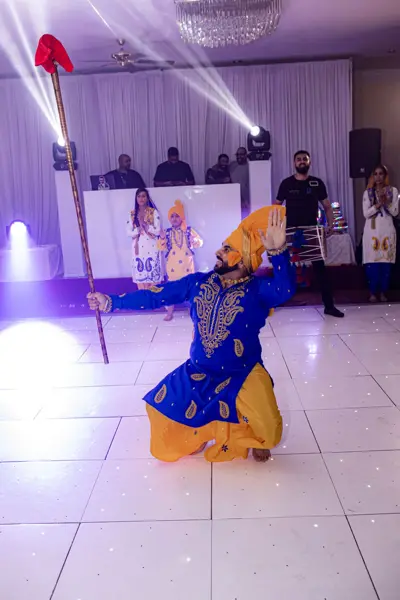Bhangra dancer performing with a decorated spear