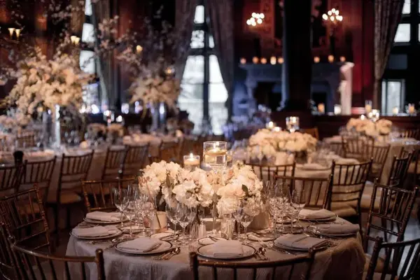 White floral centrepieces in a candlelit room