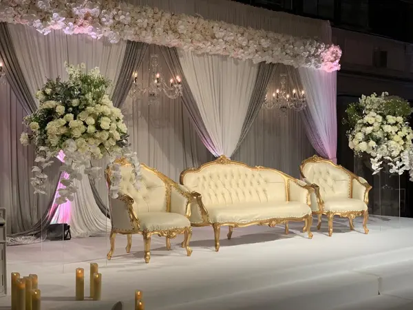Ivory drapes with white florals and gold sofas