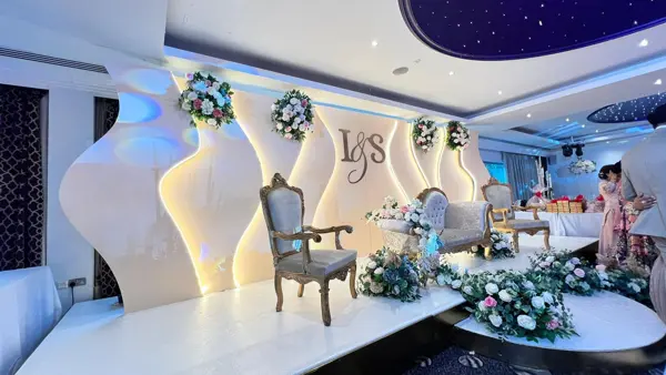 Modern white stage with curved panels and initials