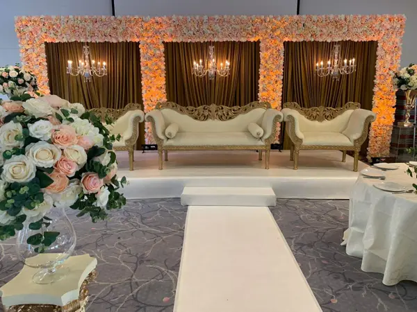 Floral wall stage with a white carpet aisle