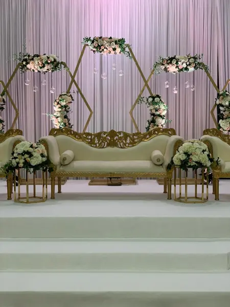 Geometric gold frames with florals behind a white sofa