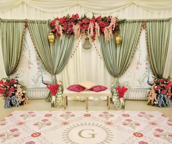 Sage drapes with red florals and a monogram floor