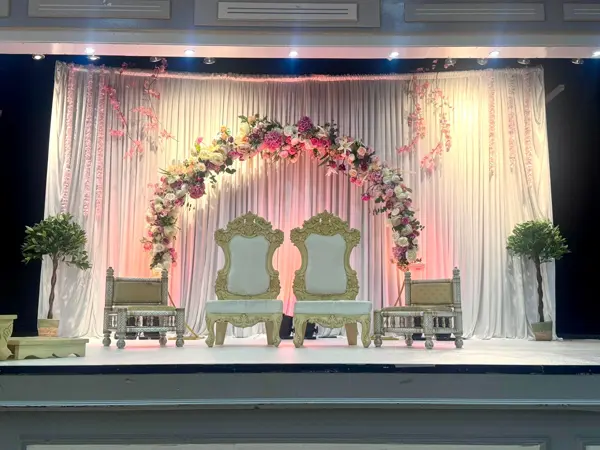 Floral arch stage with carved chairs