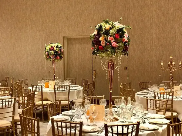 Gold chiavari chairs and tall floral centrepieces