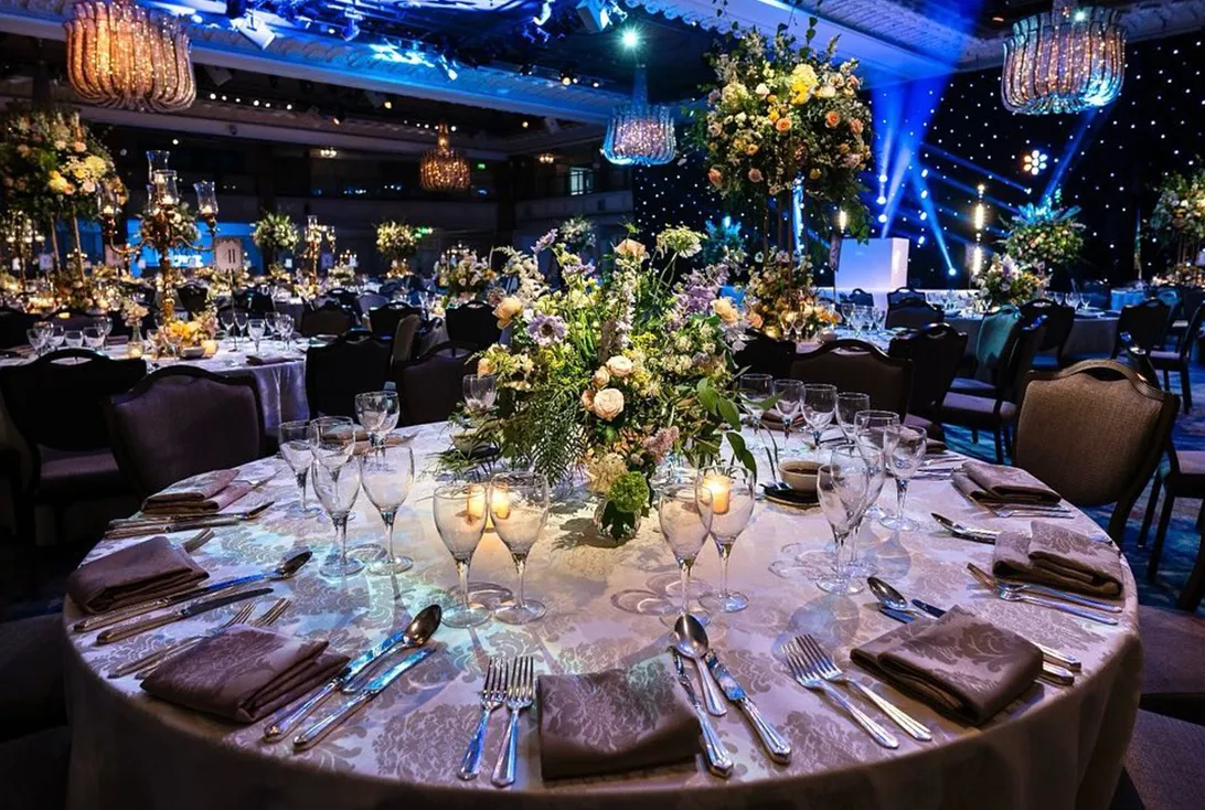 Tall floral centrepiece on a dining table in a starlit ballroom