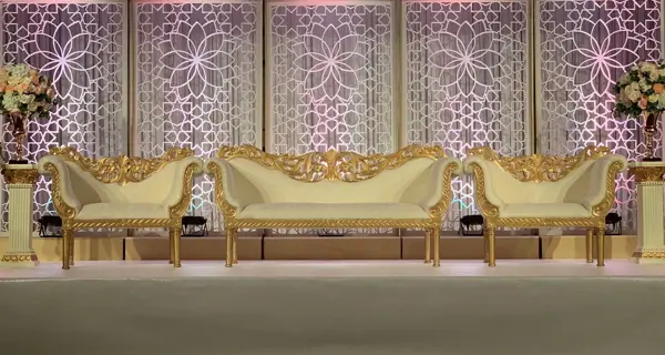 Gold lattice backdrop with ornate sofas