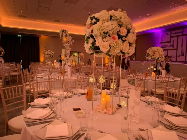 Warm-lit reception room with a large rose centrepiece