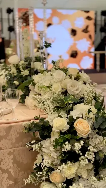 White floral centrepiece by a lit panel
