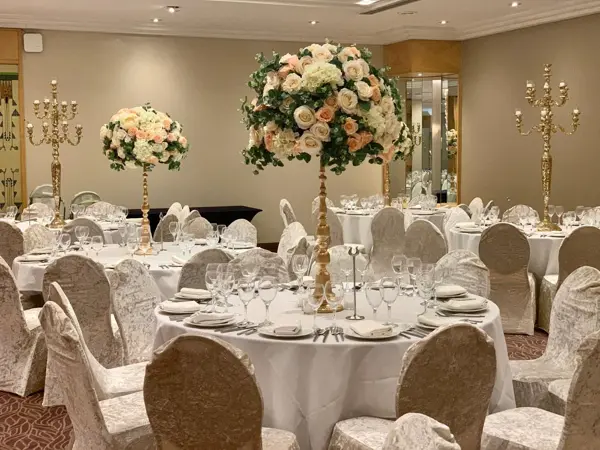 Ballroom with tall floral centrepieces and gold candelabras