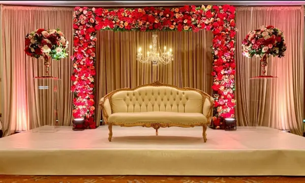 Red and pink flower wall with a gold sofa