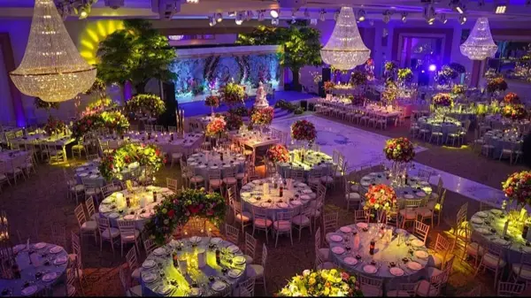 Round tables with lit florals under crystal chandeliers
