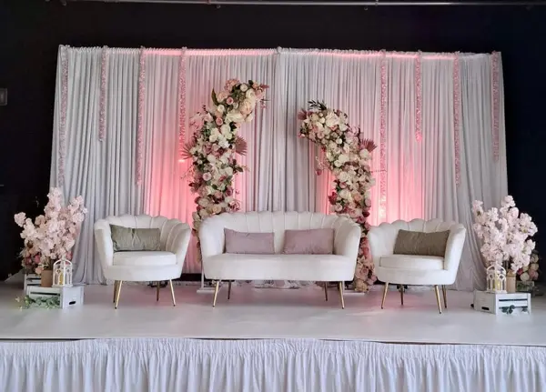 White sofas with pink florals on a stage