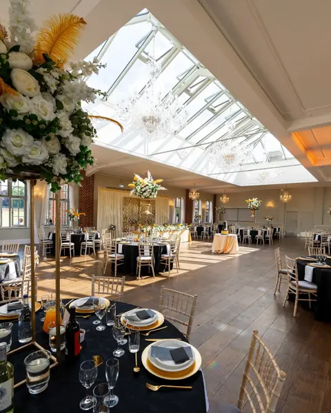 Tall florals in a glass-roofed room