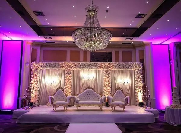 Purple-lit reception stage with a crystal chandelier