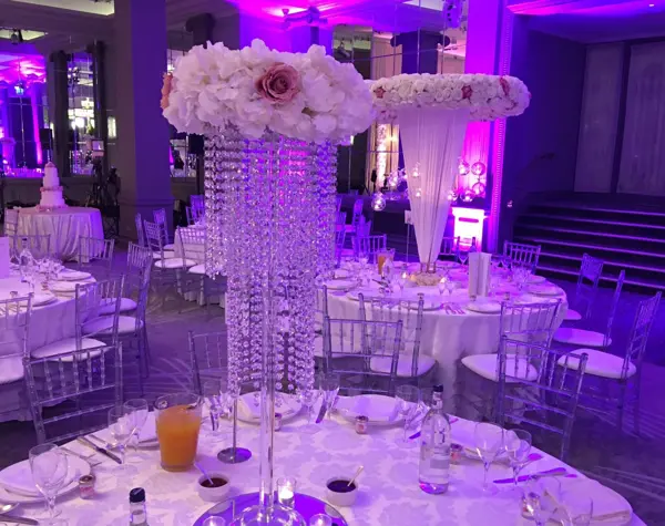 Crystal stand with roses under purple lighting