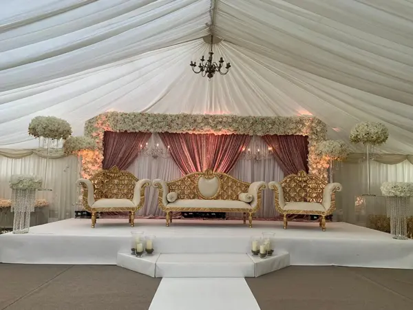 Marquee stage with drapes and gold sofas