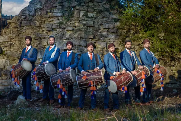 Dhol team in blue sherwanis at the ruins in Virginia Water