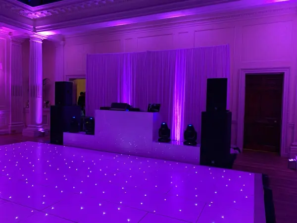 Compact DJ booth with uplighting and a starlit LED dance floor