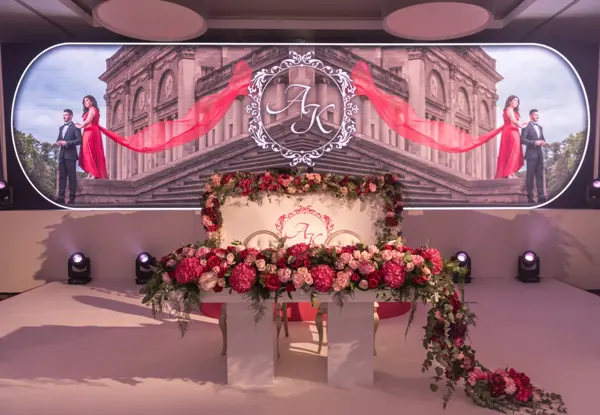 Top table framed by LED screens and florals with a DJ package at the Heston Hyde Hotel