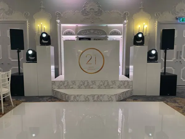 White DJ booth with moving lights and a gloss dance floor for a birthday celebration