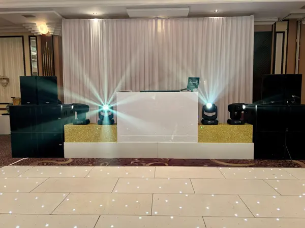 White and gold DJ booth with moving head lights and a starlit dance floor