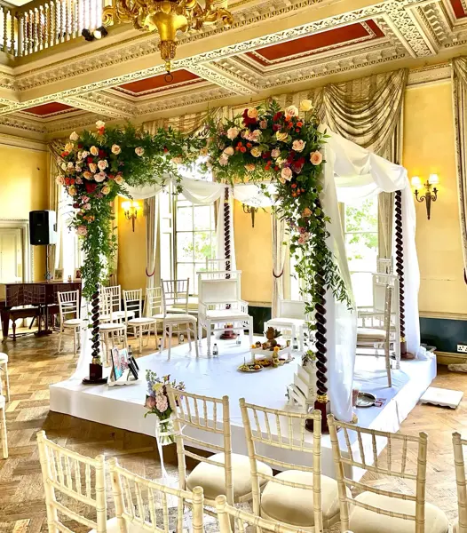 Open floral mandap in an ornate ballroom