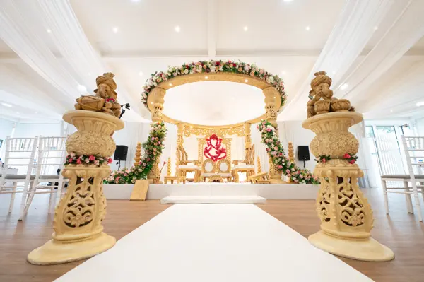 Round gold mandap with carved elephant statues at the entrance
