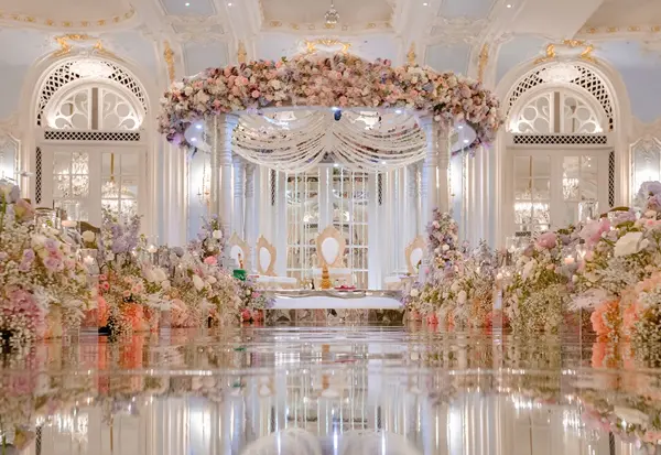 Grand ballroom mandap with a mirrored aisle and lavish floral displays