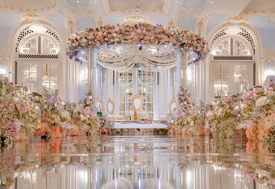 Grand ballroom mandap with a mirrored aisle and lavish floral displays