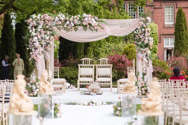 Wooden mandap dressed in pastel flowers in a garden