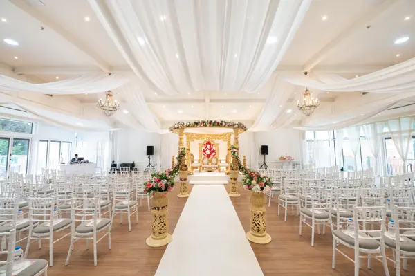 Full ceremony room with mandap, aisle and rows of chairs