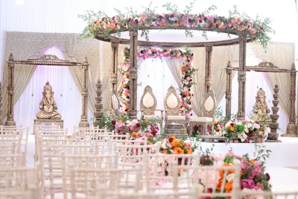Round mandap with floral canopy and carved Ganesh statues