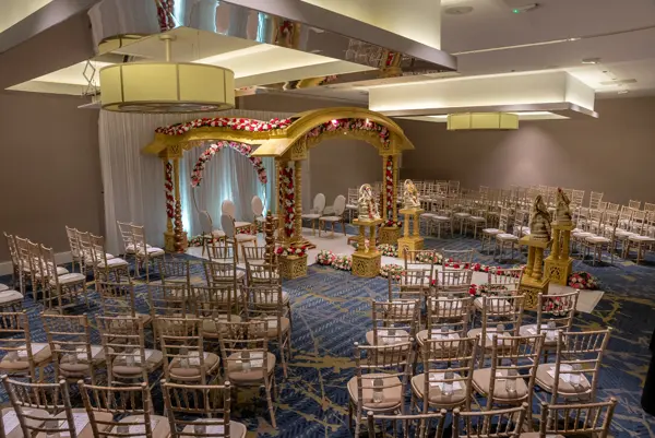 Gold mandap with rows of guest chairs