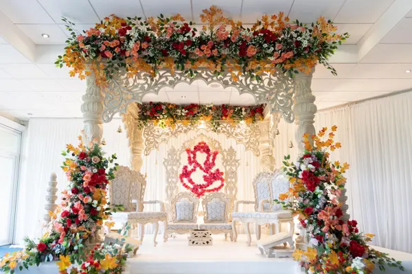 Mandap with a full floral canopy and a Ganesh backdrop