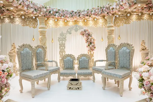 Mandap with ivory and gold chairs and floral pillars