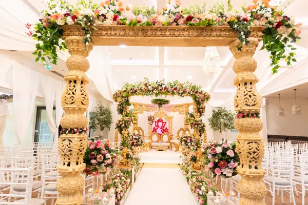 Tall carved pillars with a floral canopy over the aisle