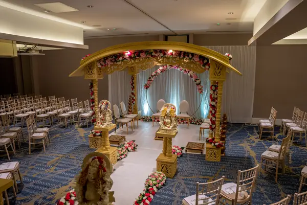 Gold mandap with chairs set out for guests