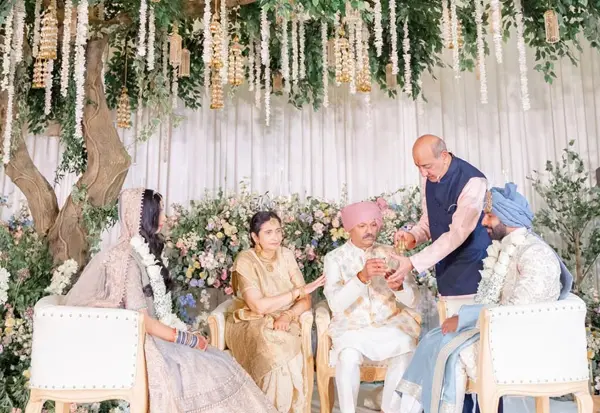 Family members blessing the couple under hanging florals