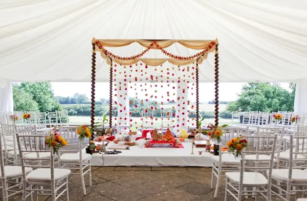 Simple draped mandap with garlands in a marquee