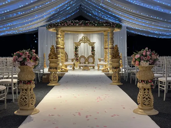 Gold mandap in a marquee with fairy light ceiling