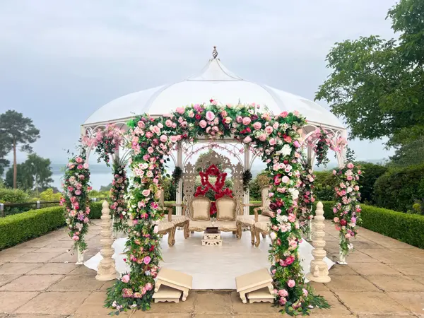 Round mandap wrapped in flowers on an outdoor terrace