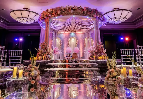 Mandap on a lit stage with floral canopy and crystal details