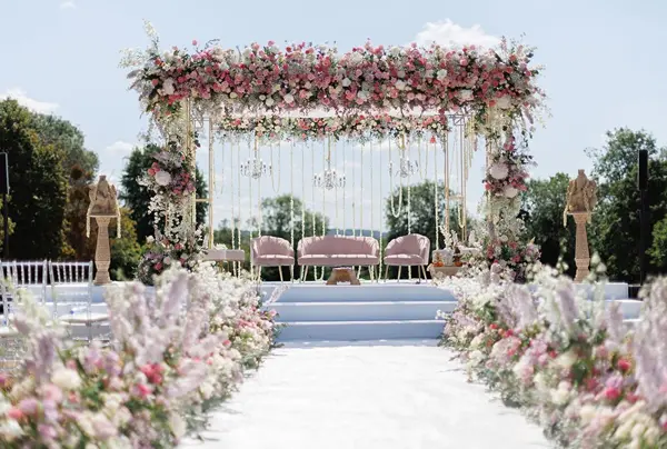 Outdoor mandap with a floral canopy and a pastel flower aisle