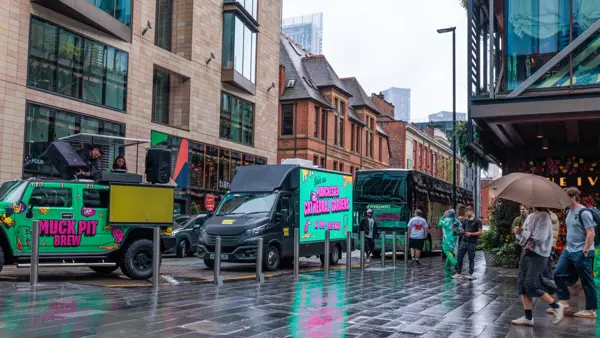 DJ truck and branded van on a wet city street