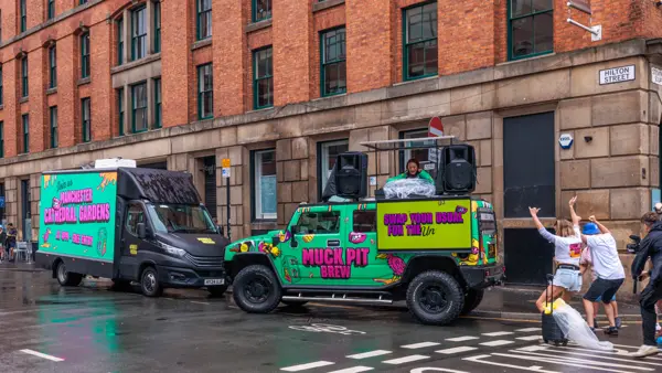 DJ truck and van parked on a city street with dancers