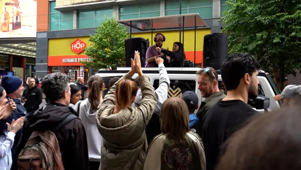 People dancing in front of a DJ truck